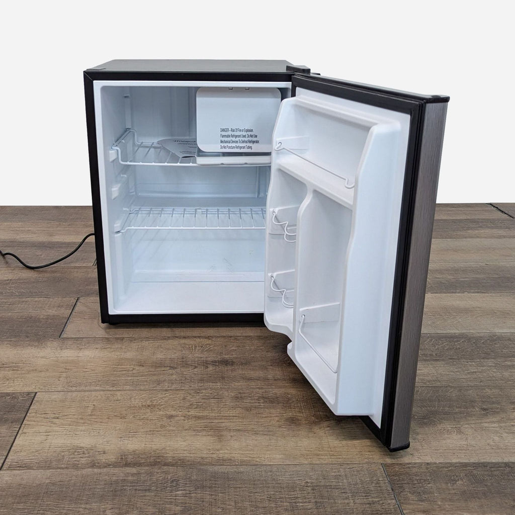 a small refrigerator with a black door and a white door.