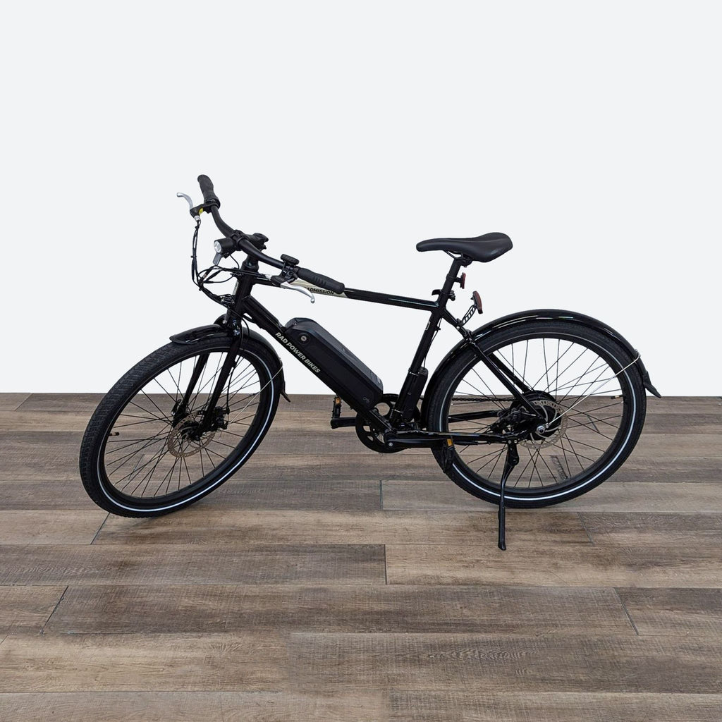 a black electric bike on a wooden floor.