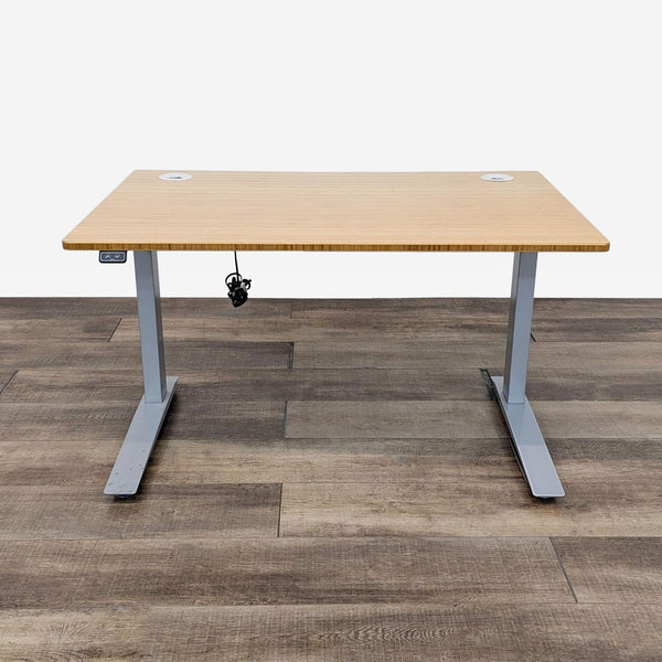 Reperch desk in a low position, wood top, gray legs on wood floor.