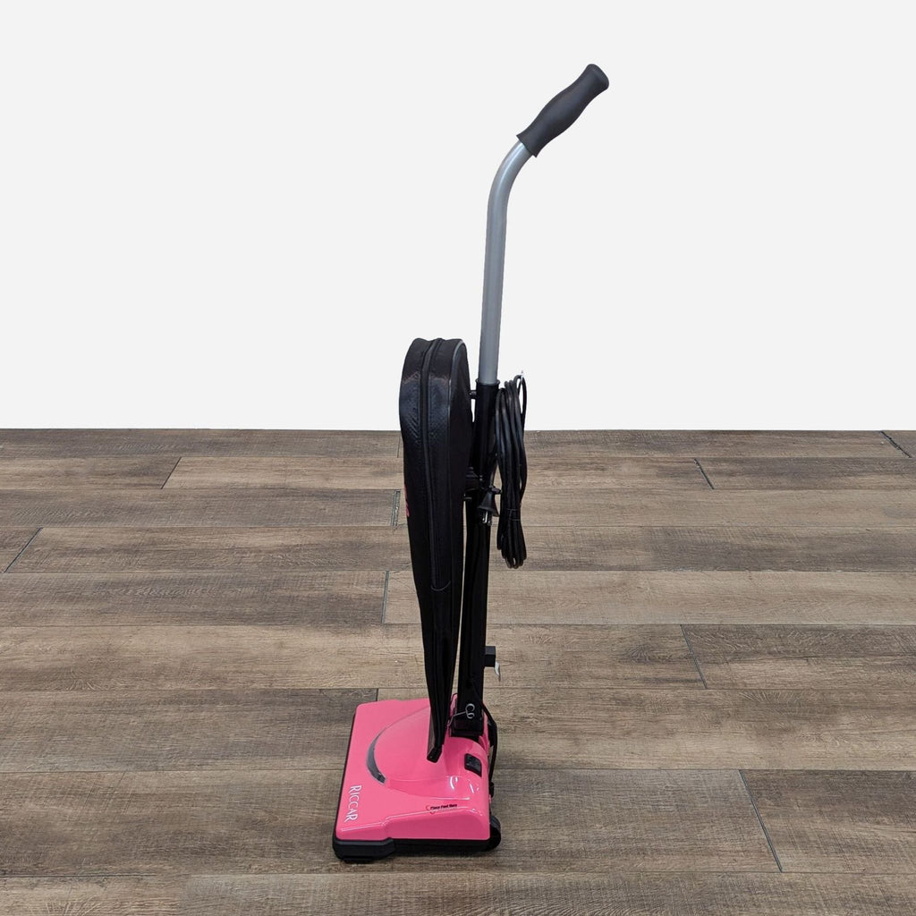 a pink vacuum cleaner on a wooden floor.