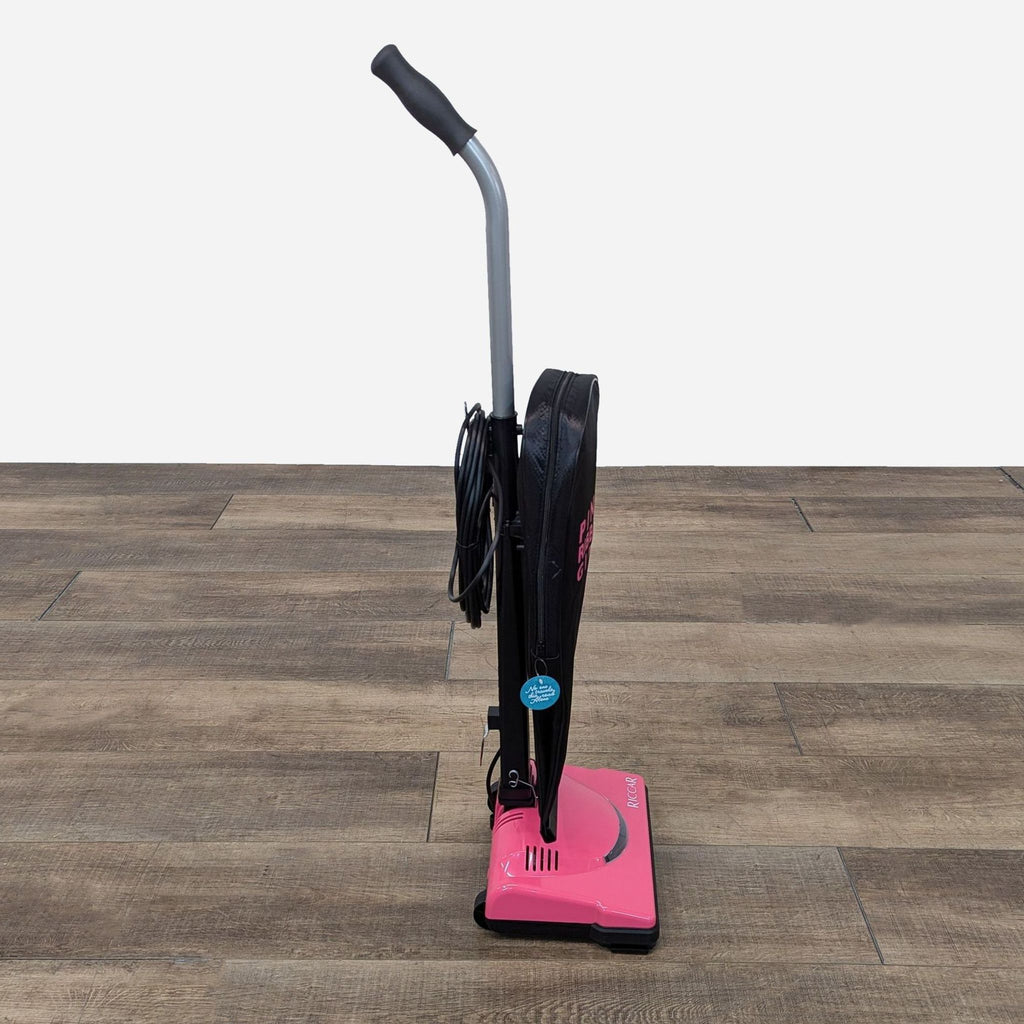 a pink vacuum cleaner on a wooden floor.