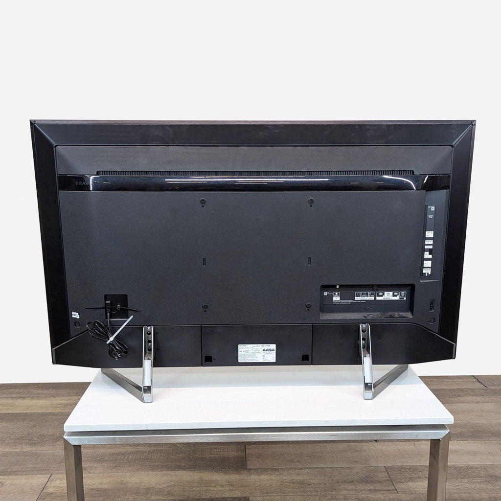 a large black tv with a white table.