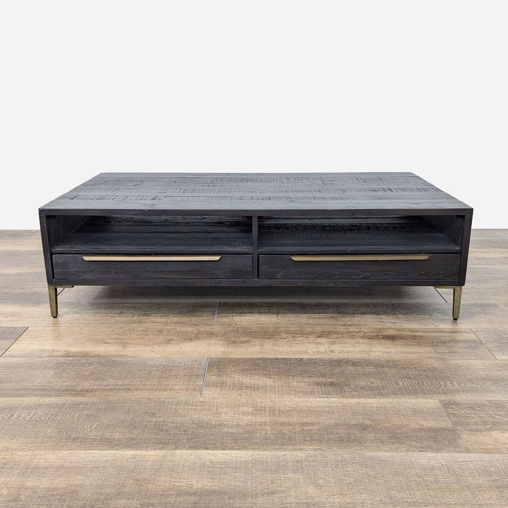 the coffee table is made from a black lacquered wood with a brass drawer.