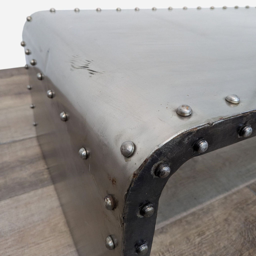 a metal coffee table with rivets