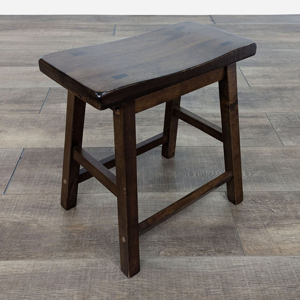 a small, solid wood stool with a single seat.