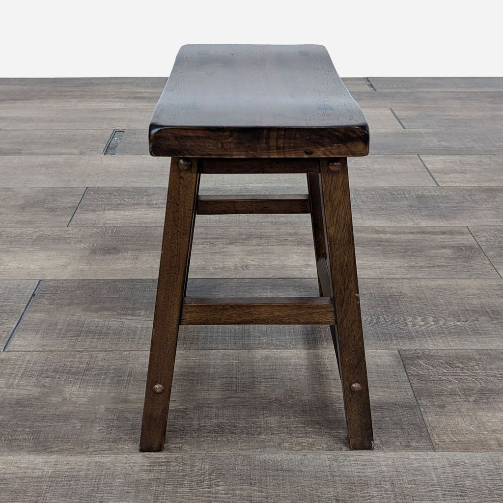 the stool is made from a solid wood and has a black leather seat.