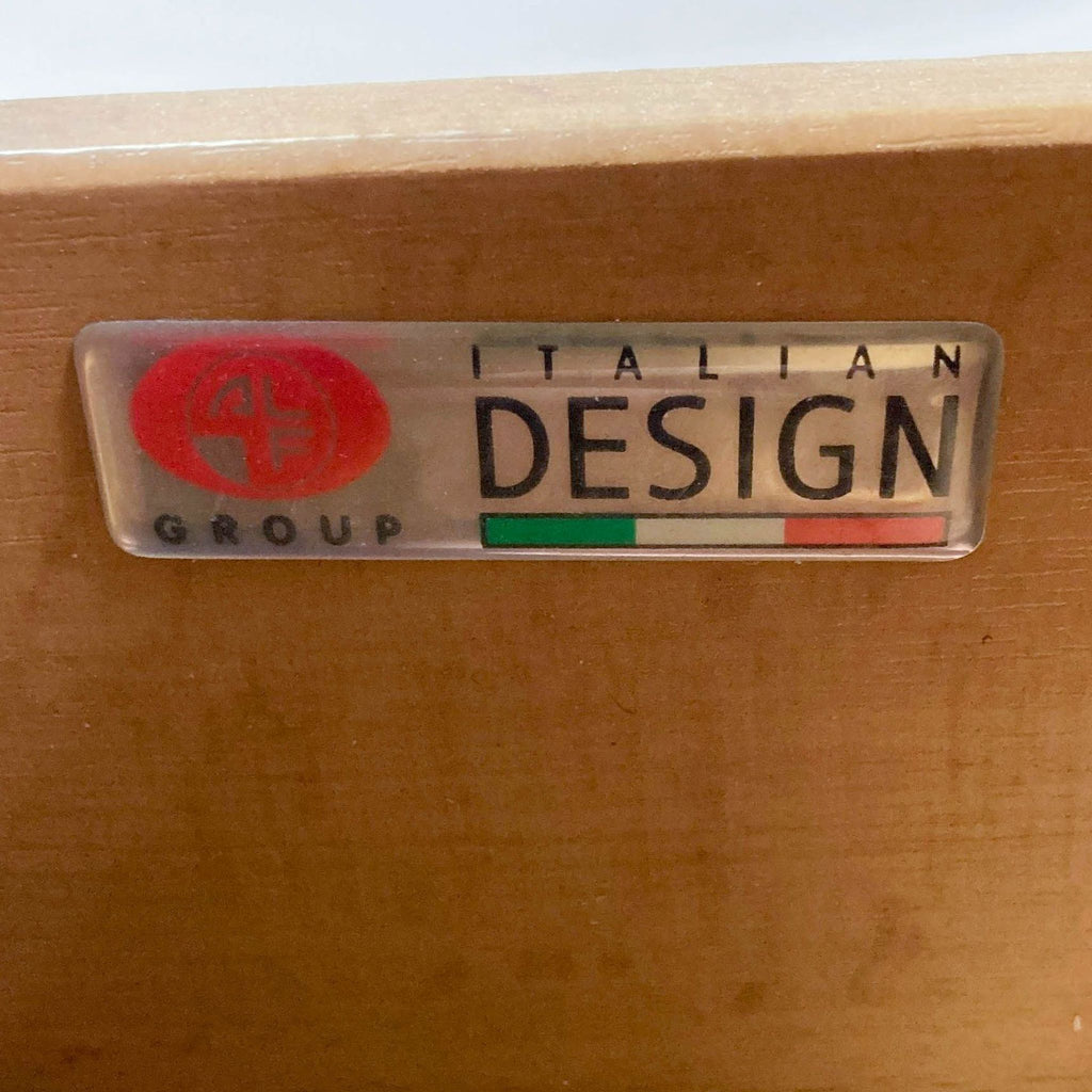 a metal logo on a wooden desk.