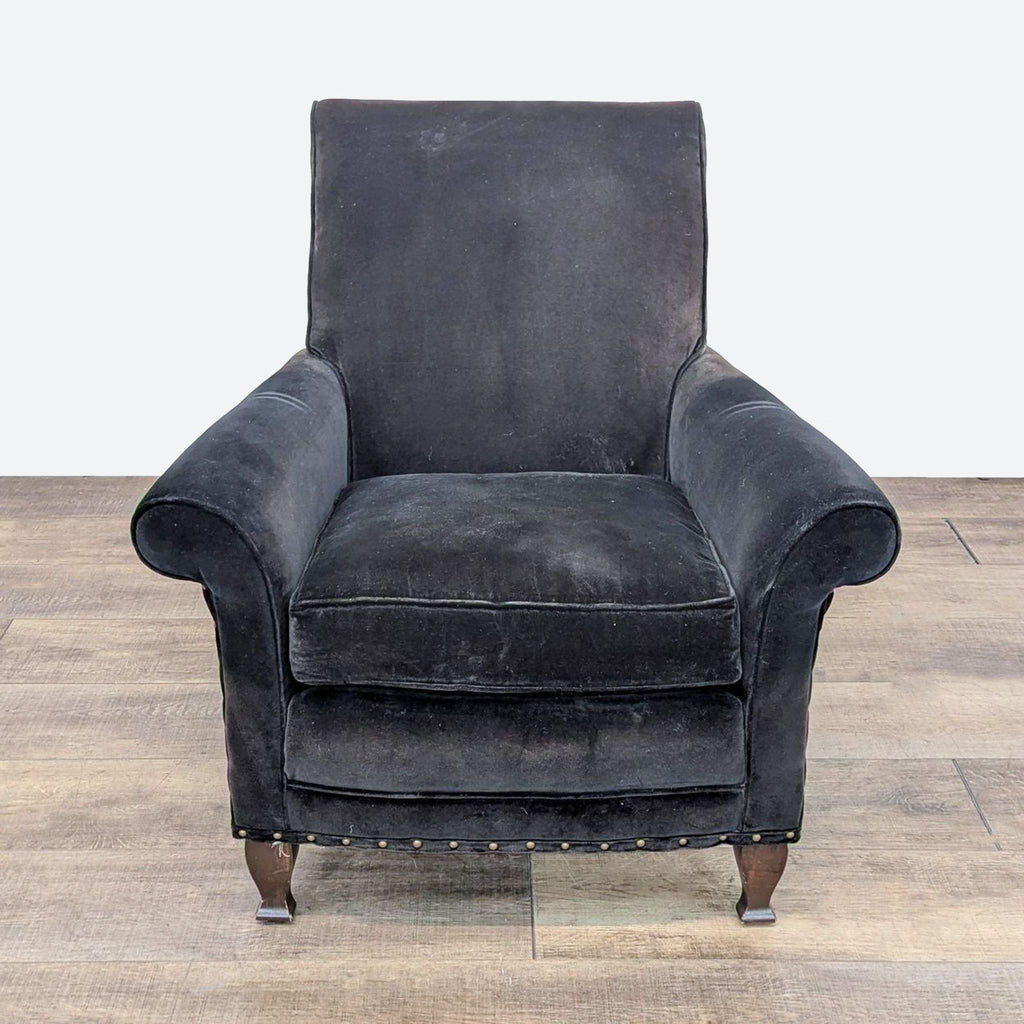 a black velvet wingback chair with a brown velvet frame and a black velvet back.