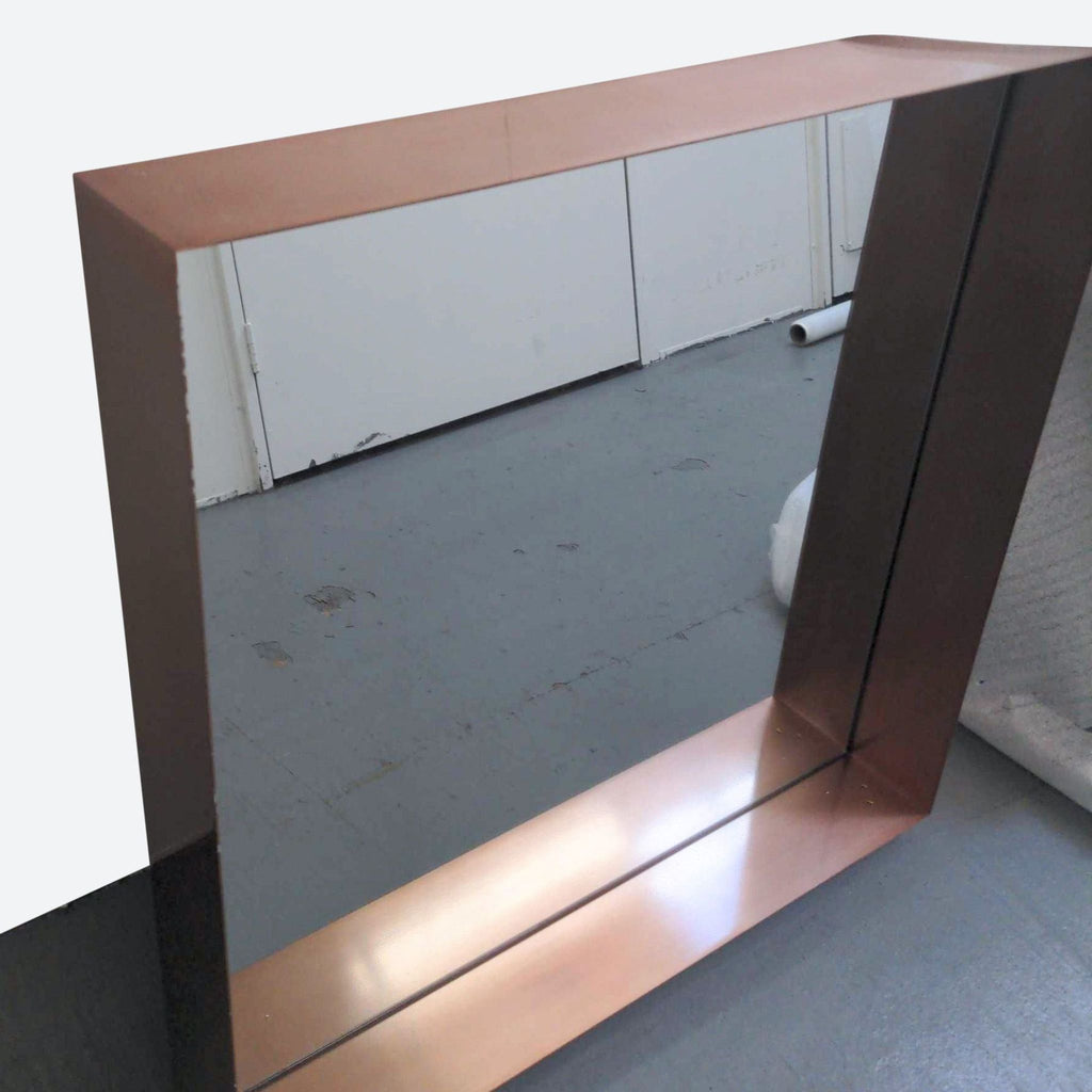 a large mirror with a copper finish.