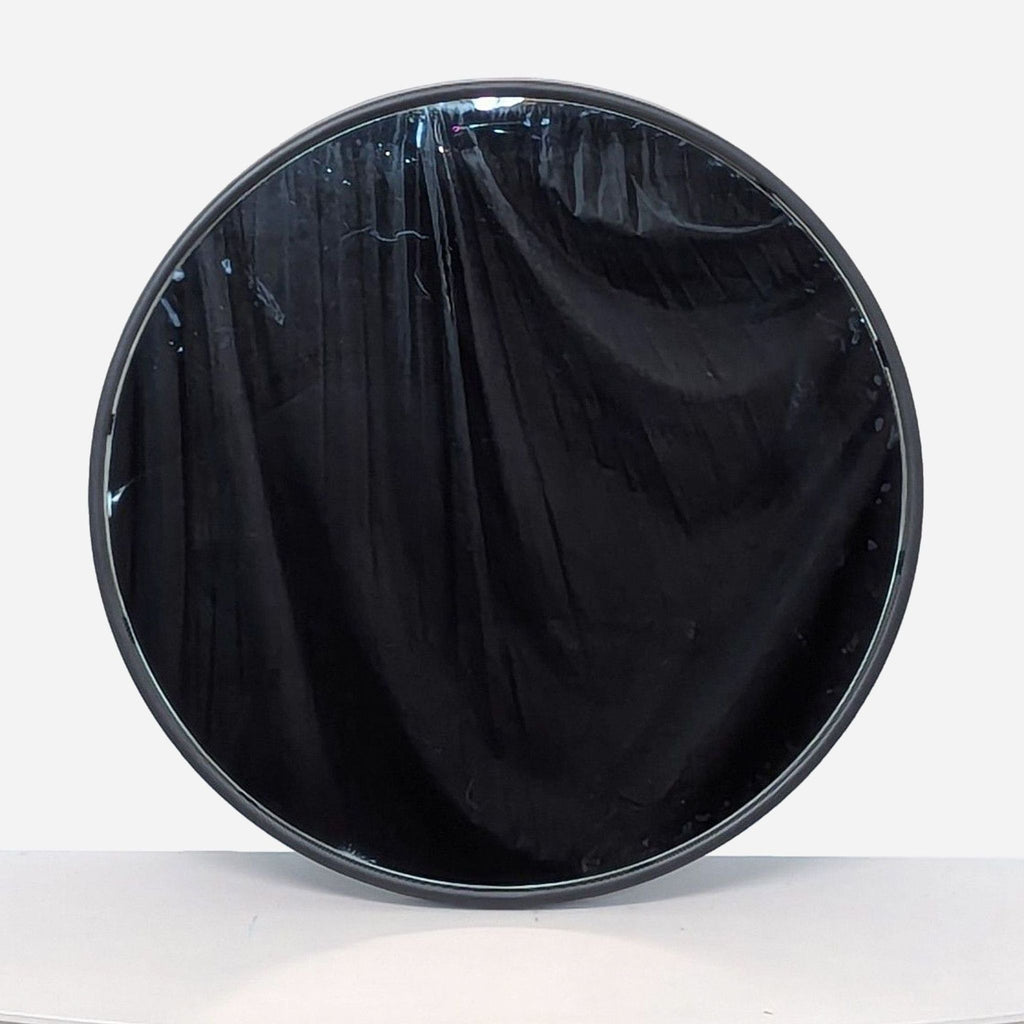 a round mirror with a black velvet cover.