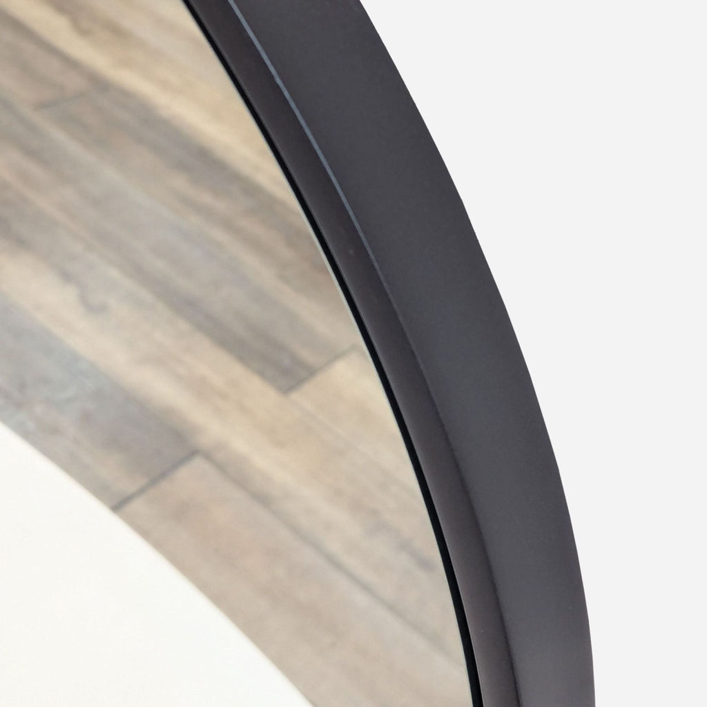 the frame of the mirror is made of a dark grey finish.