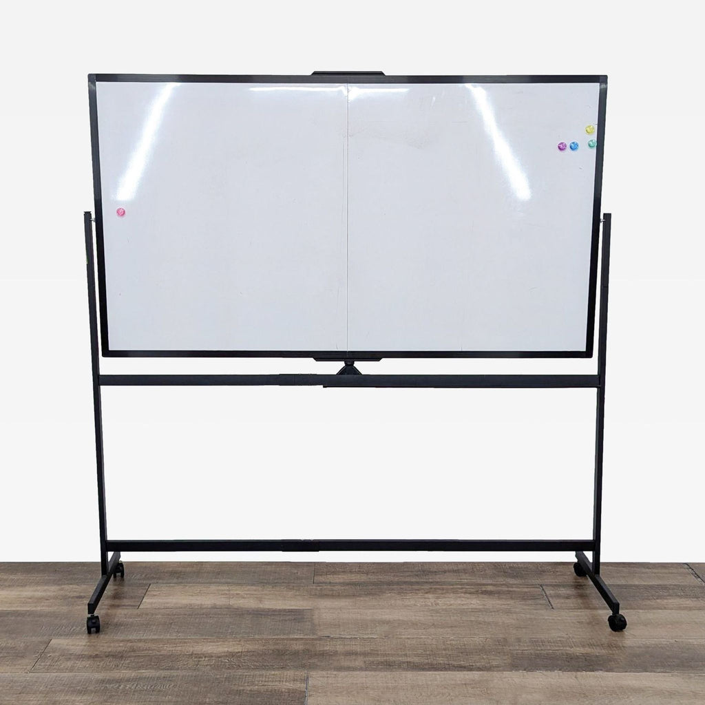 a whiteboard with a black frame and whiteboard on a wooden floor.