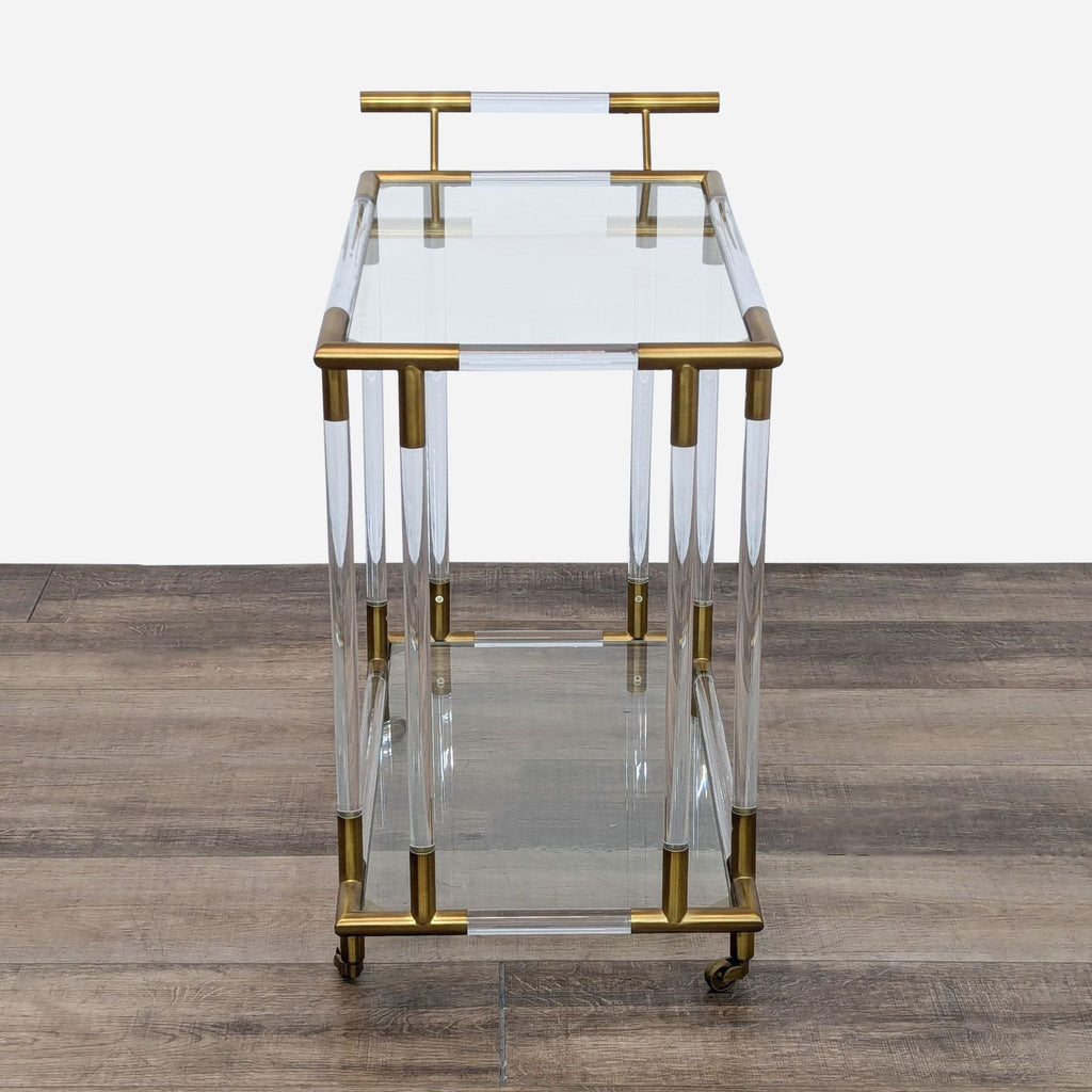 a brass and glass side table with brass handles and a shelf.
