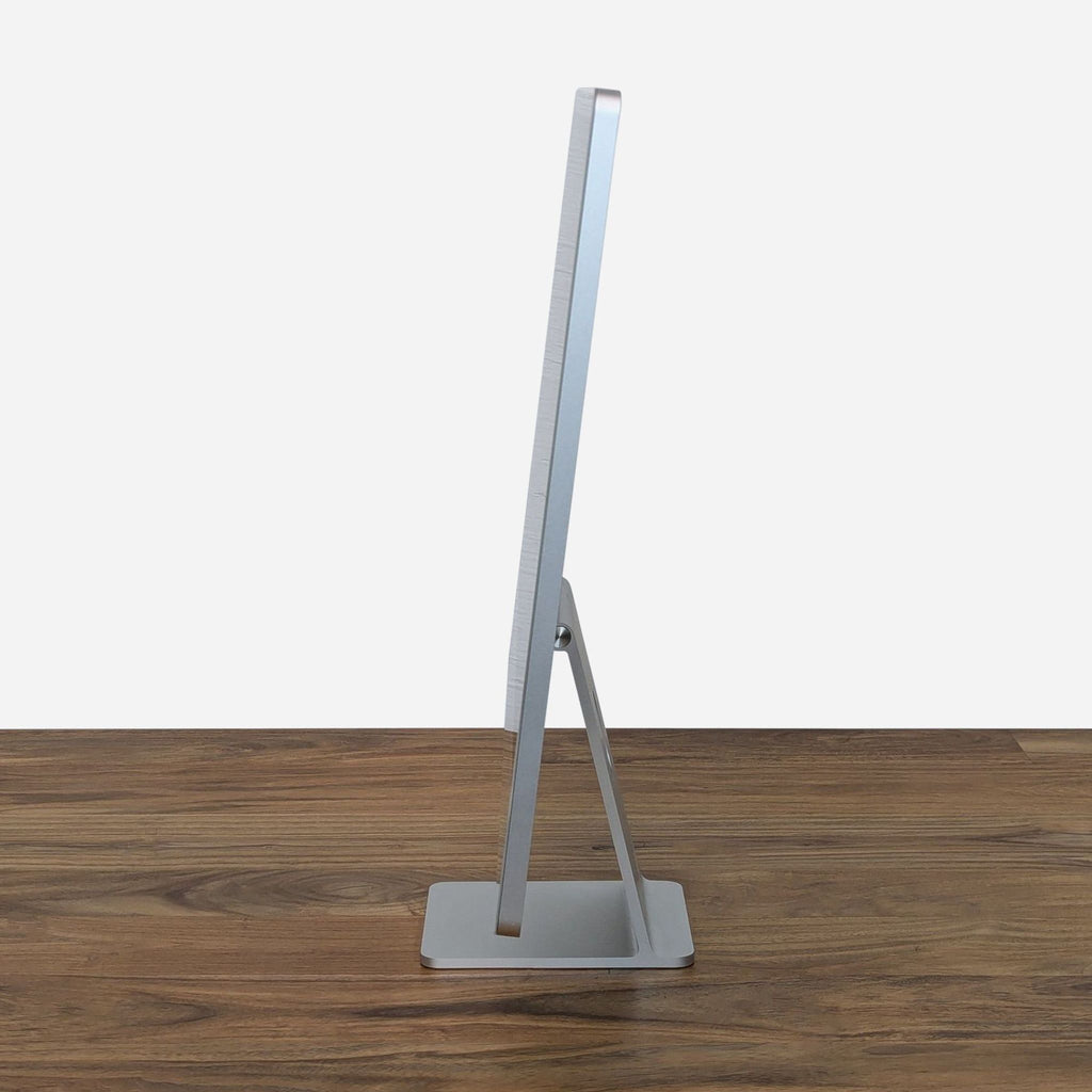 a metal easel with a stand on a wooden table.