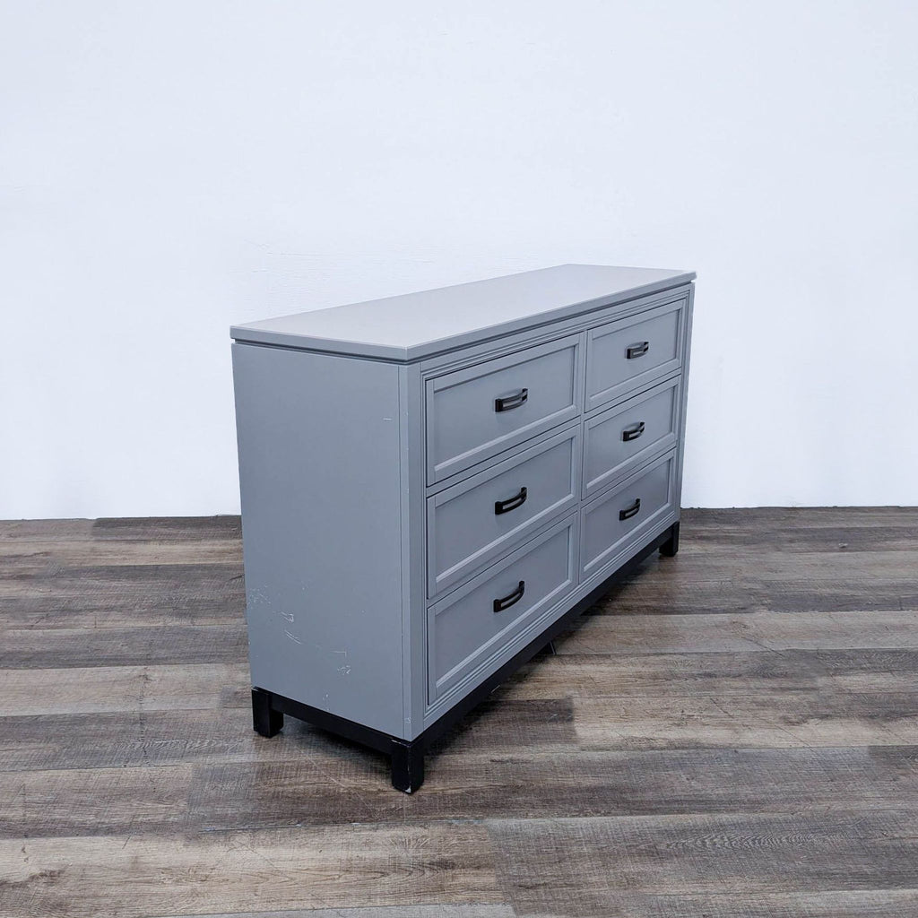 a large vintage french provincial grey dresser with a black metal frame.