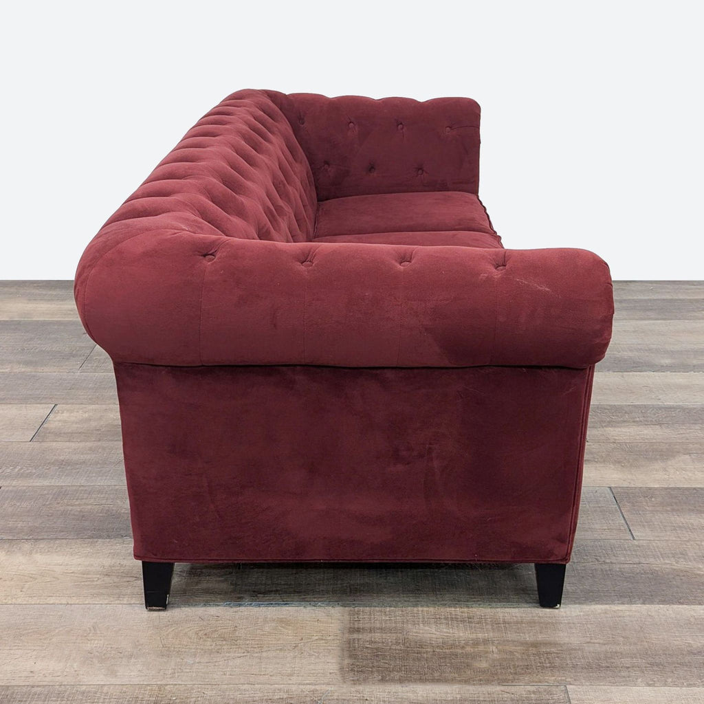 the [ unused0 ] sofa is a deep red velvet sofa with a buttoned back and a