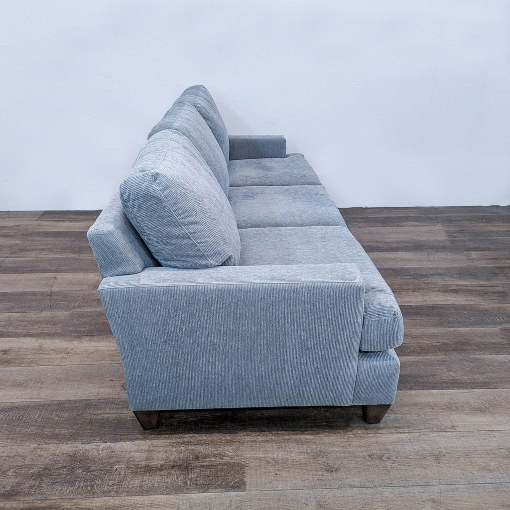 a pair of blue linen sofas with matching cushions