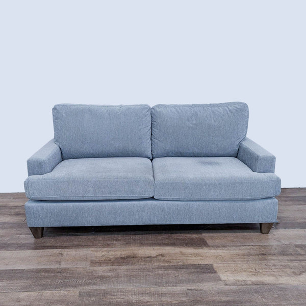 a white couch with a black leather couch cushion 