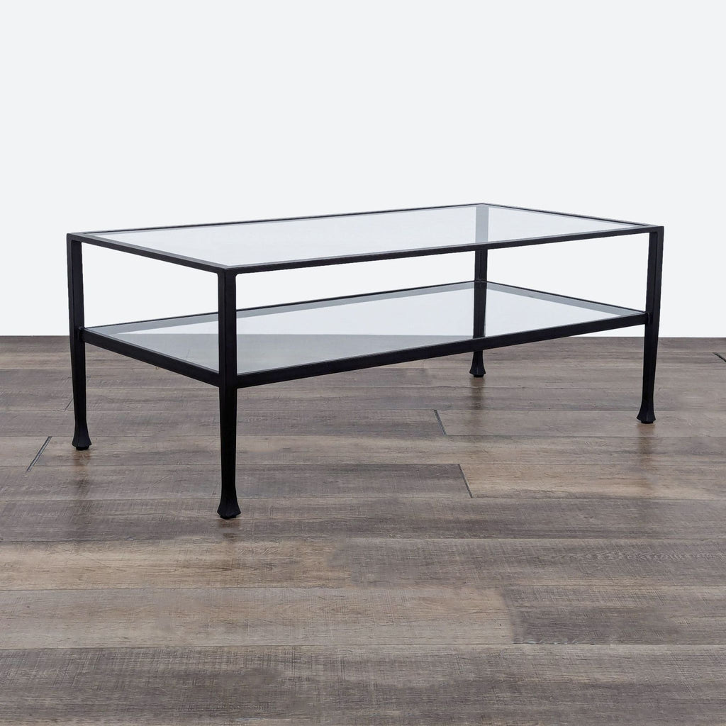 Crate & Barrel coffee table featuring a black metal frame, glass surface, and lower shelf on wood floor.