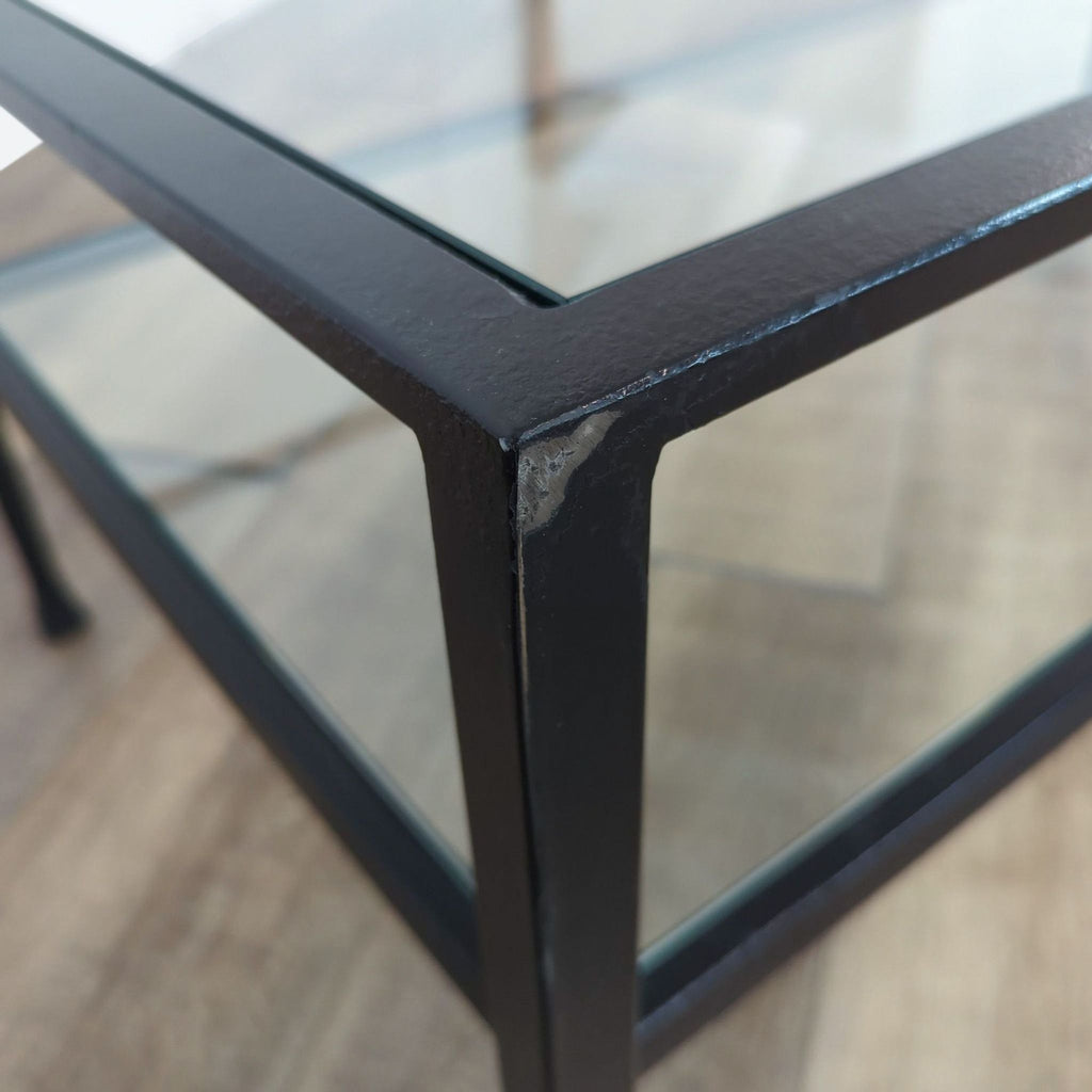 Close-up of the black metal frame of a Crate & Barrel coffee table, highlighting corner details.