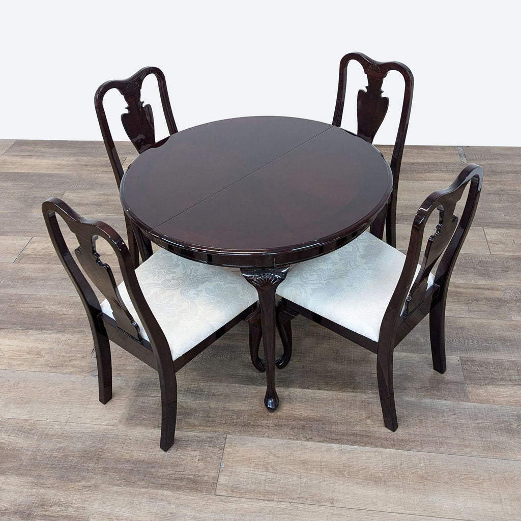 a set of four dining chairs and a table.