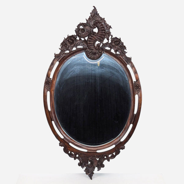 a large oval mirror with carved wood frame.