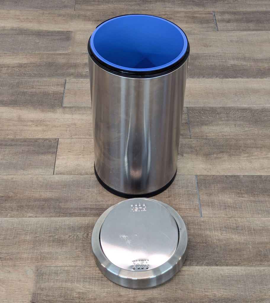 the [ unused0 ] is a stainless steel trash can with a blue lid.