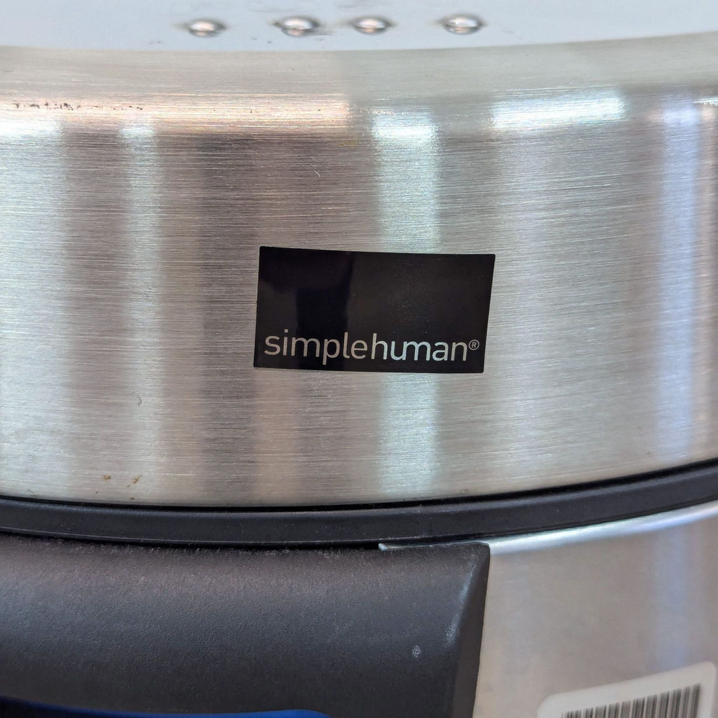 a simple human logo on a stainless steel appliance.