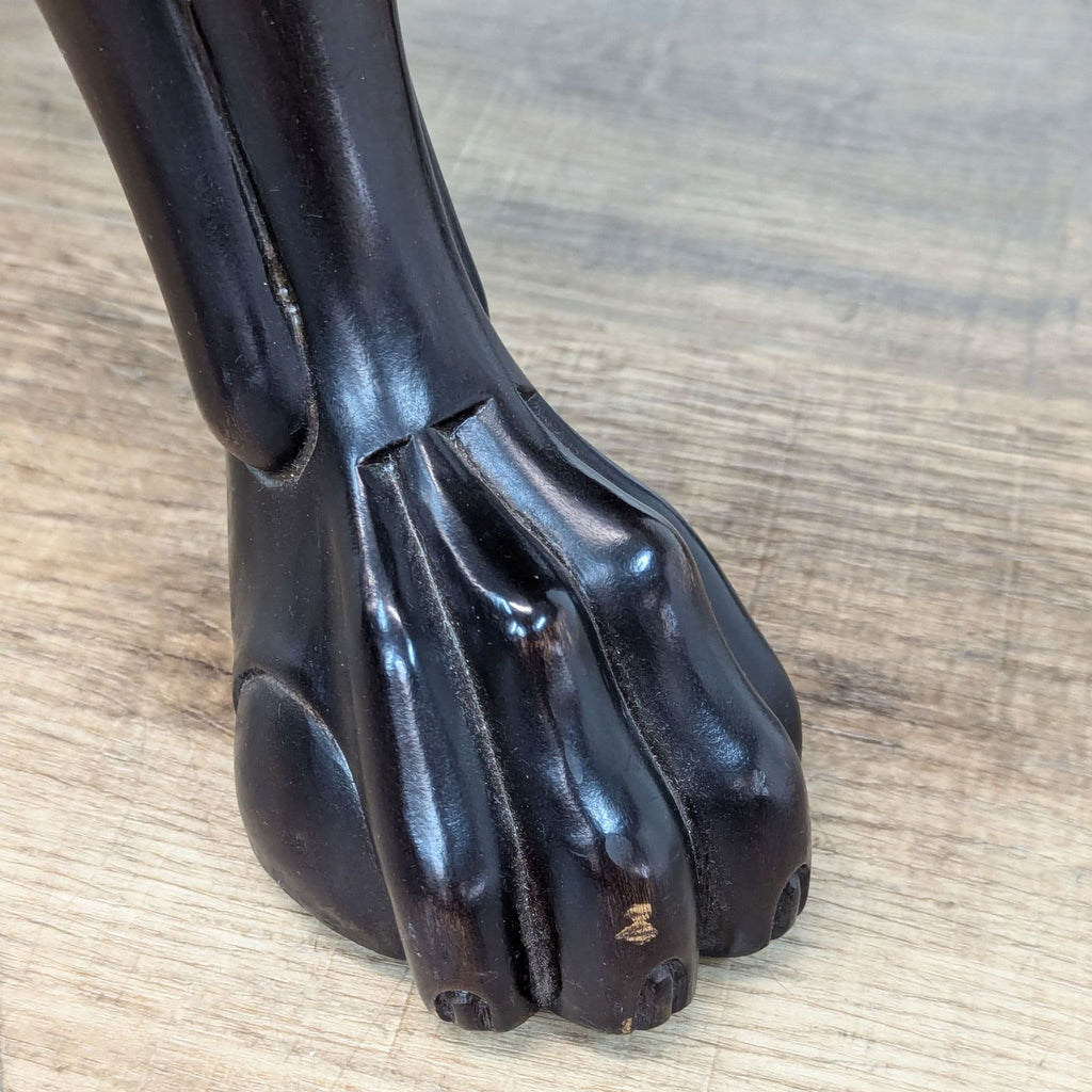 a large black and white wood sculpture of a dog's foot.
