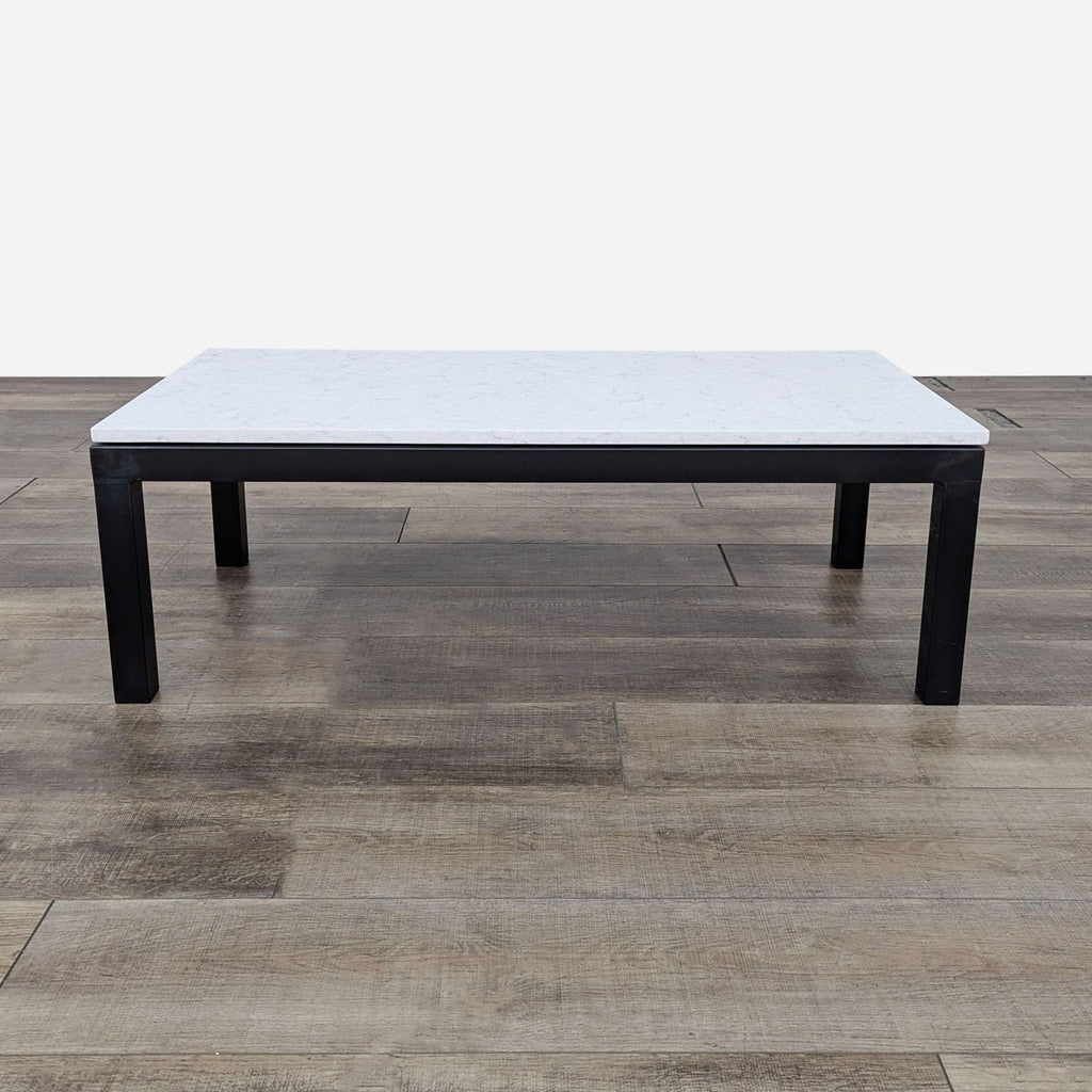 Side view of a Reperch coffee table with a metal base and a light-colored rectangular top.