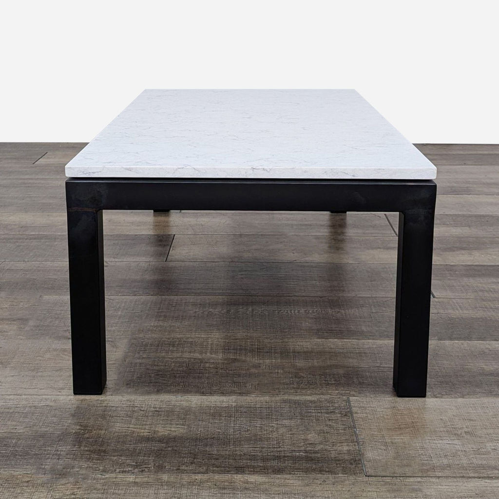 Front view of a Reperch coffee table featuring a sturdy metal base and a smooth, light-colored top.