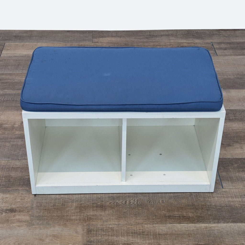 a blue and white storage bench with a blue cushion.