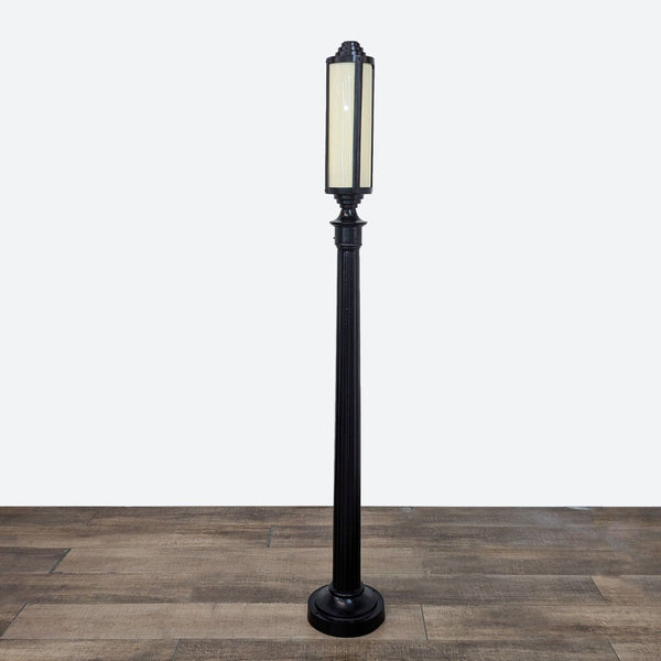 a black metal floor lamp with a white shade.