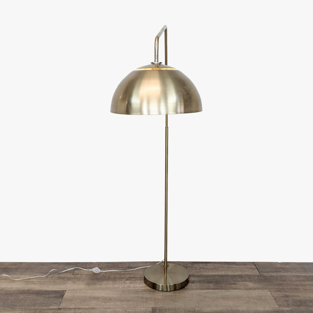 a brass table lamp with a brass shade.