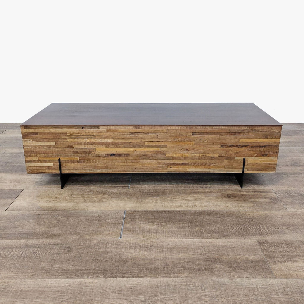 the coffee table is made from reclaimed wood and features a black metal base.