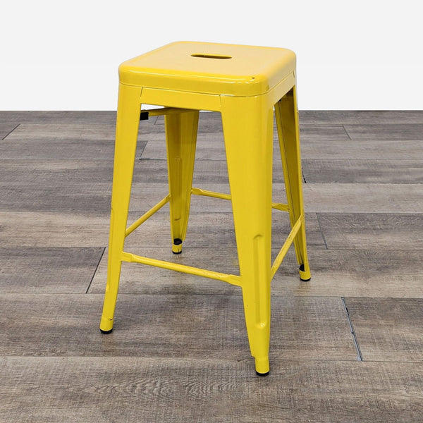 the stool is a bright yellow stool with a metal seat.