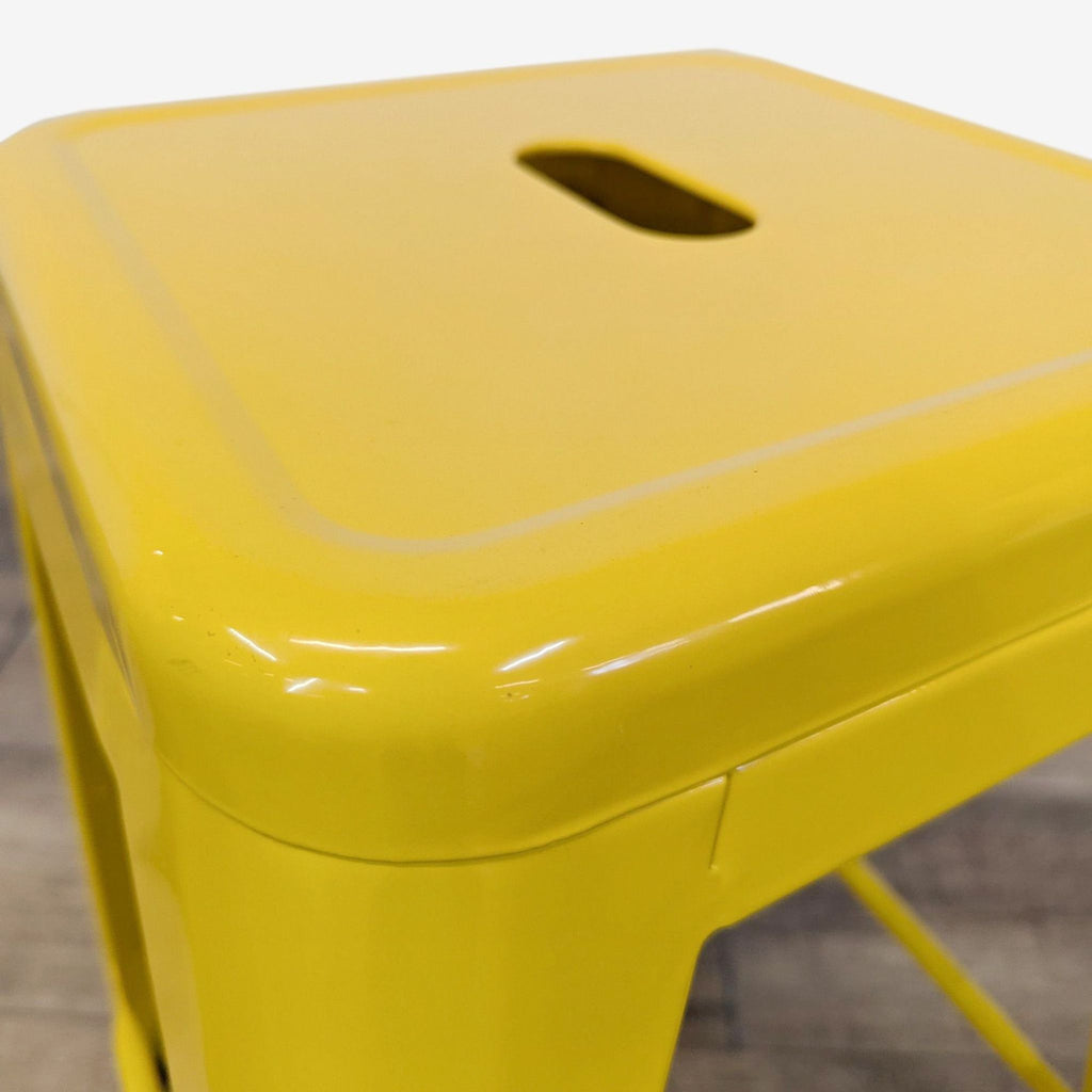 the [ unused0 ] stool is a bright yellow plastic stool with a metal lid. the stool