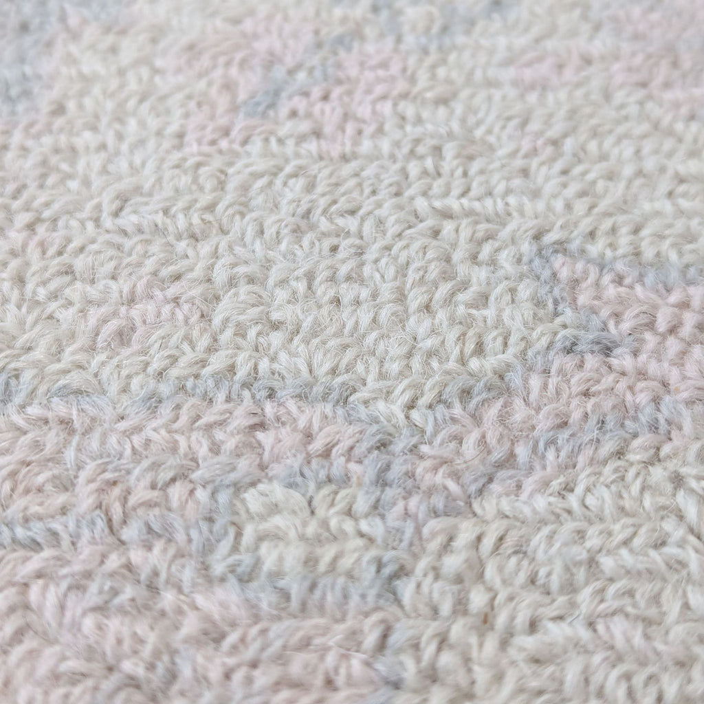 Macro shot highlighting the wool texture and weave of the blush pink Pottery Barn Kids area rug.