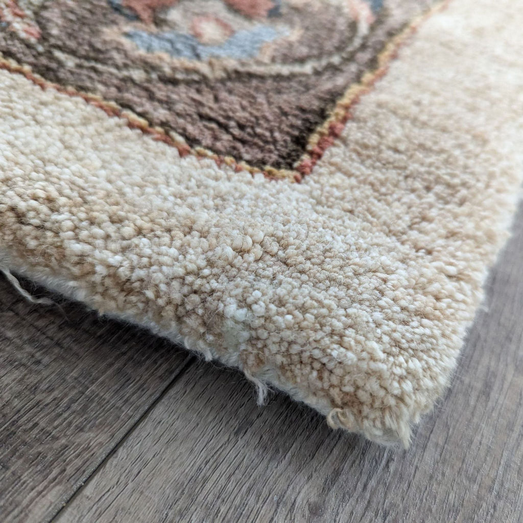 Side profile showing the thickness and texture of Monaco tan Viscose pile rug's edge.