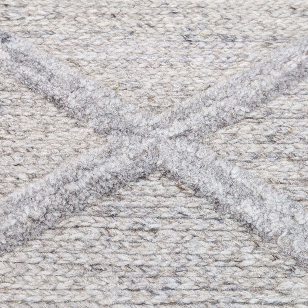 a close up of a grey rug with a cross pattern.