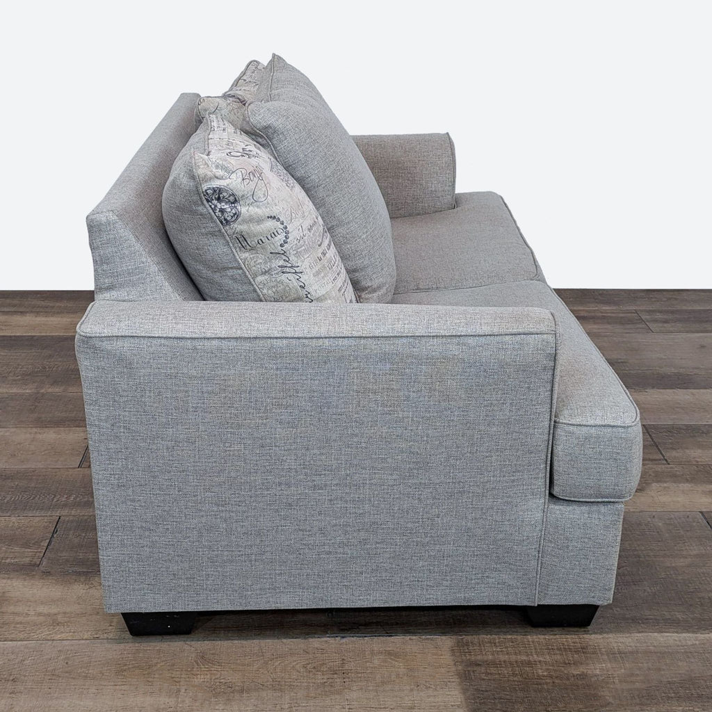 Side view of the Velletri loveseat by Ashley with flared arms and neutral, linen-like chenille fabric.