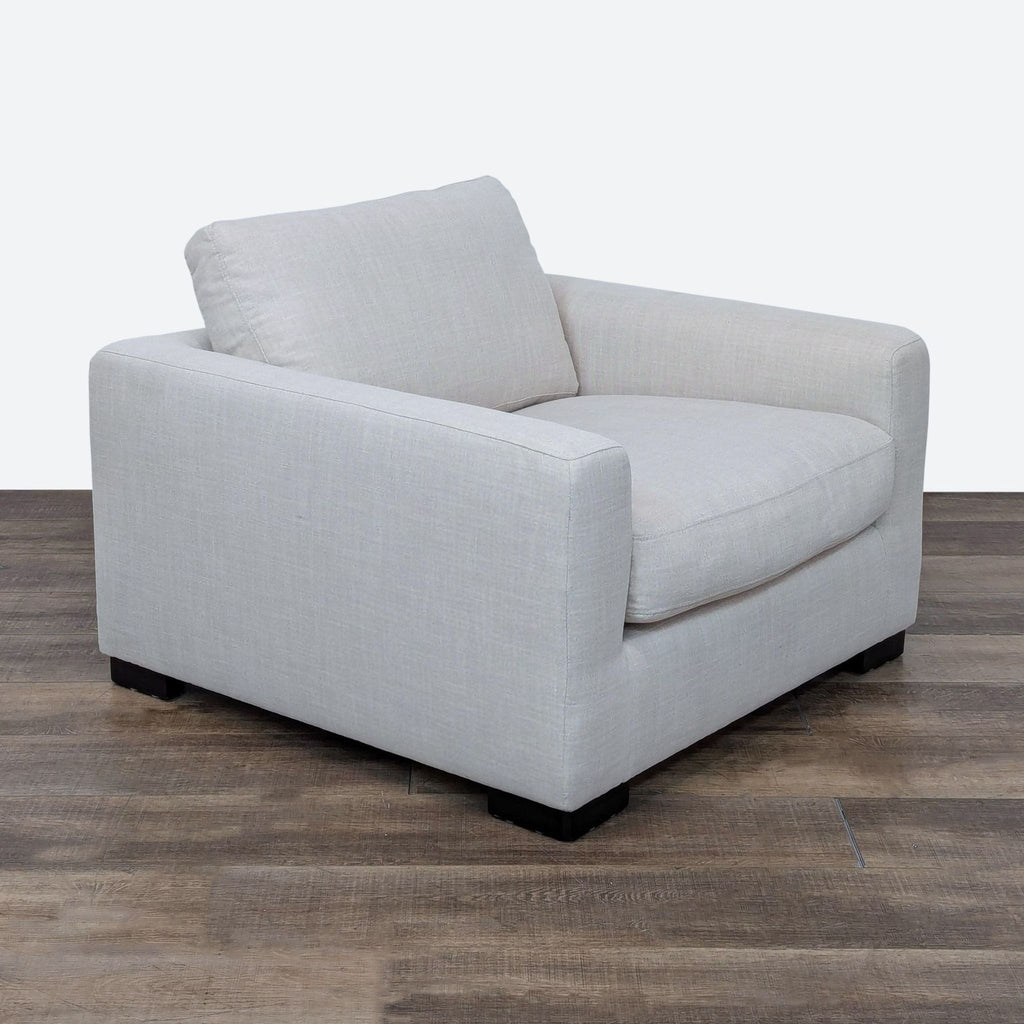 Three-quarter view of a Stone & Beam lounge chair showcasing its cushioned seating and armrests.