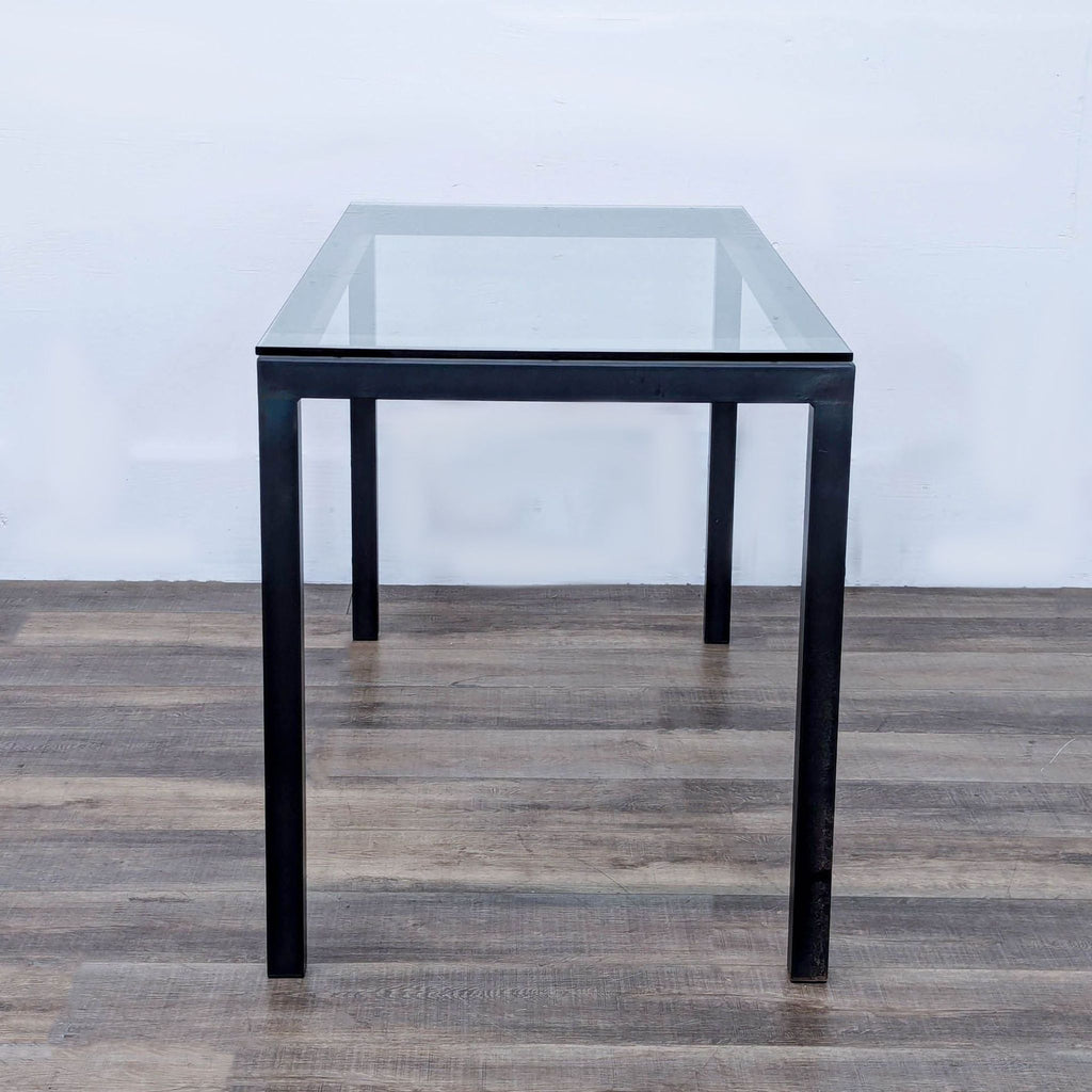 a mid century modern black glass table with a glass top.