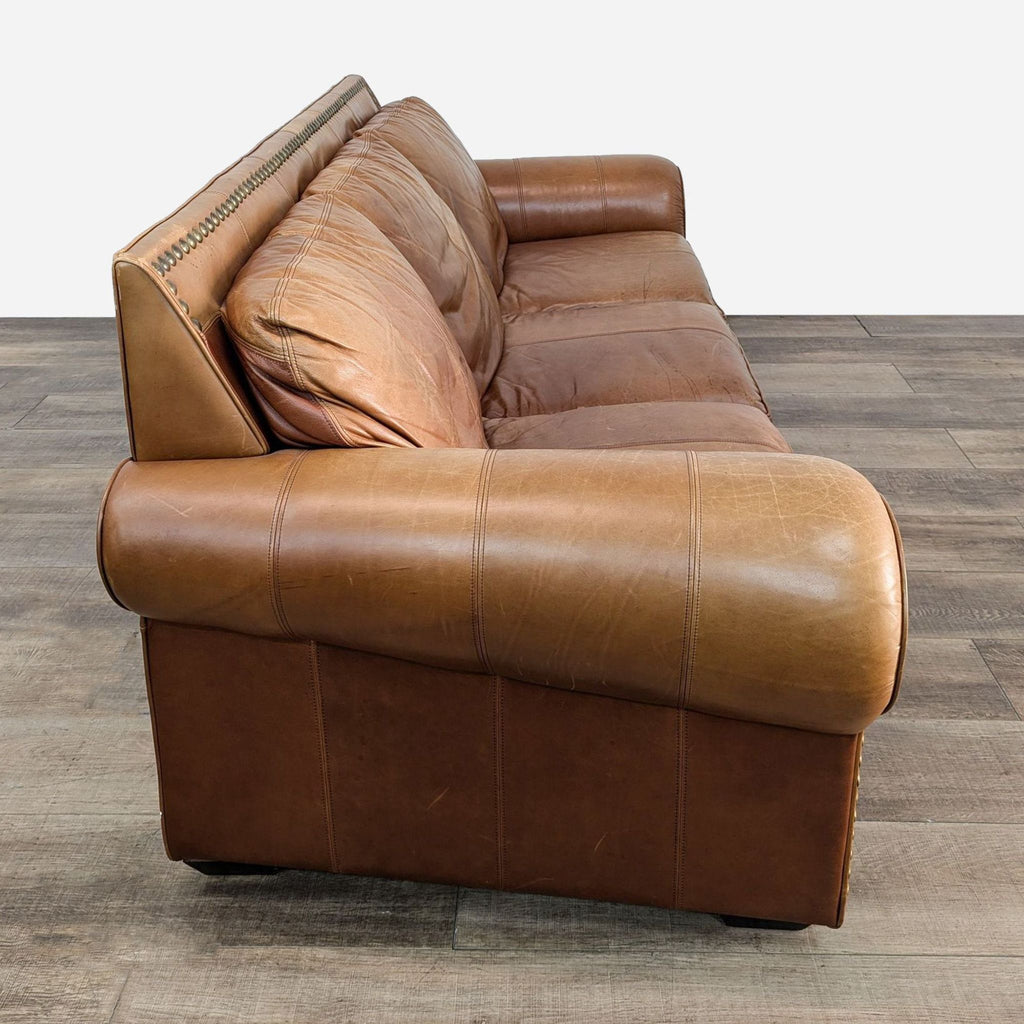 a leather sofa with a brown leather back and a cushion.