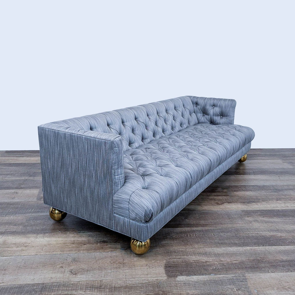 3. Angled view of Jonathan Adler 3-seat sofa featuring deep tufted blue-gray upholstery and brass legs.