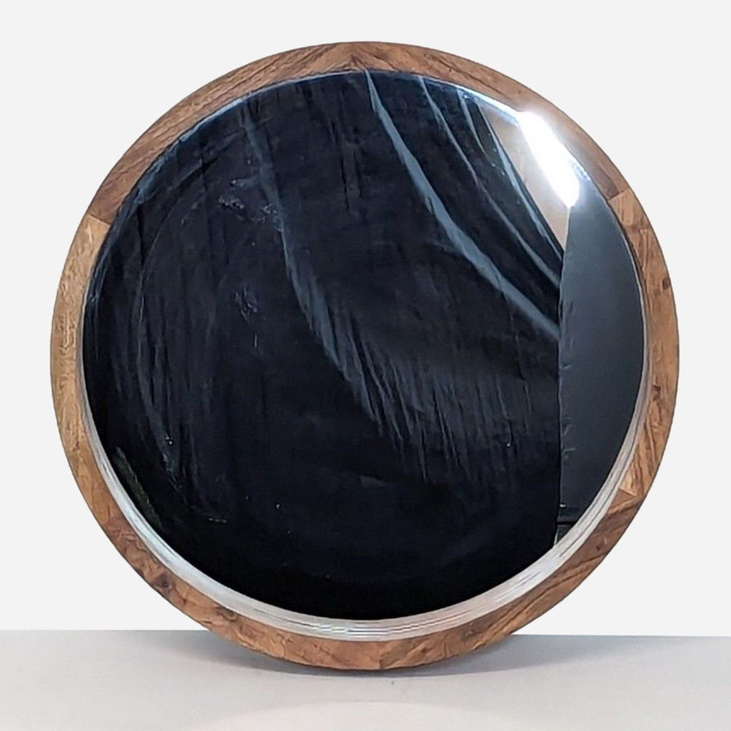 a round mirror with a black walnut finish.