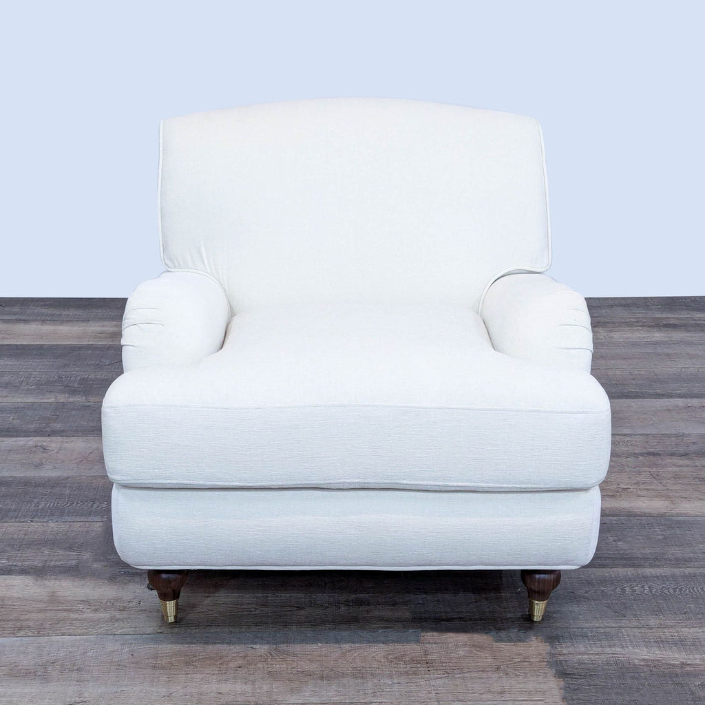 a white chair with a gold footstool