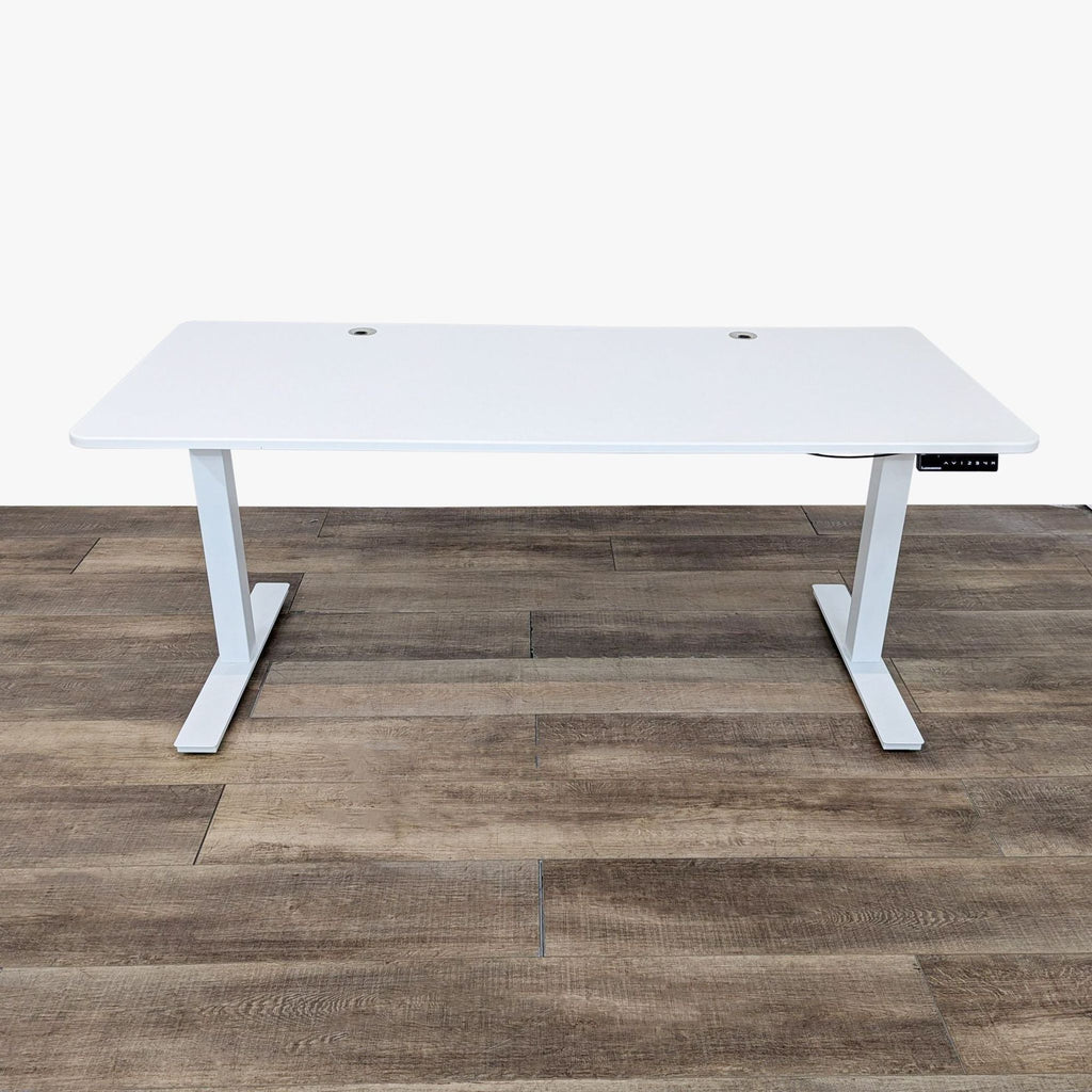 White Autonomous desk that adjusts from approximately 29" to 48" height, shown on a wooden floor.
