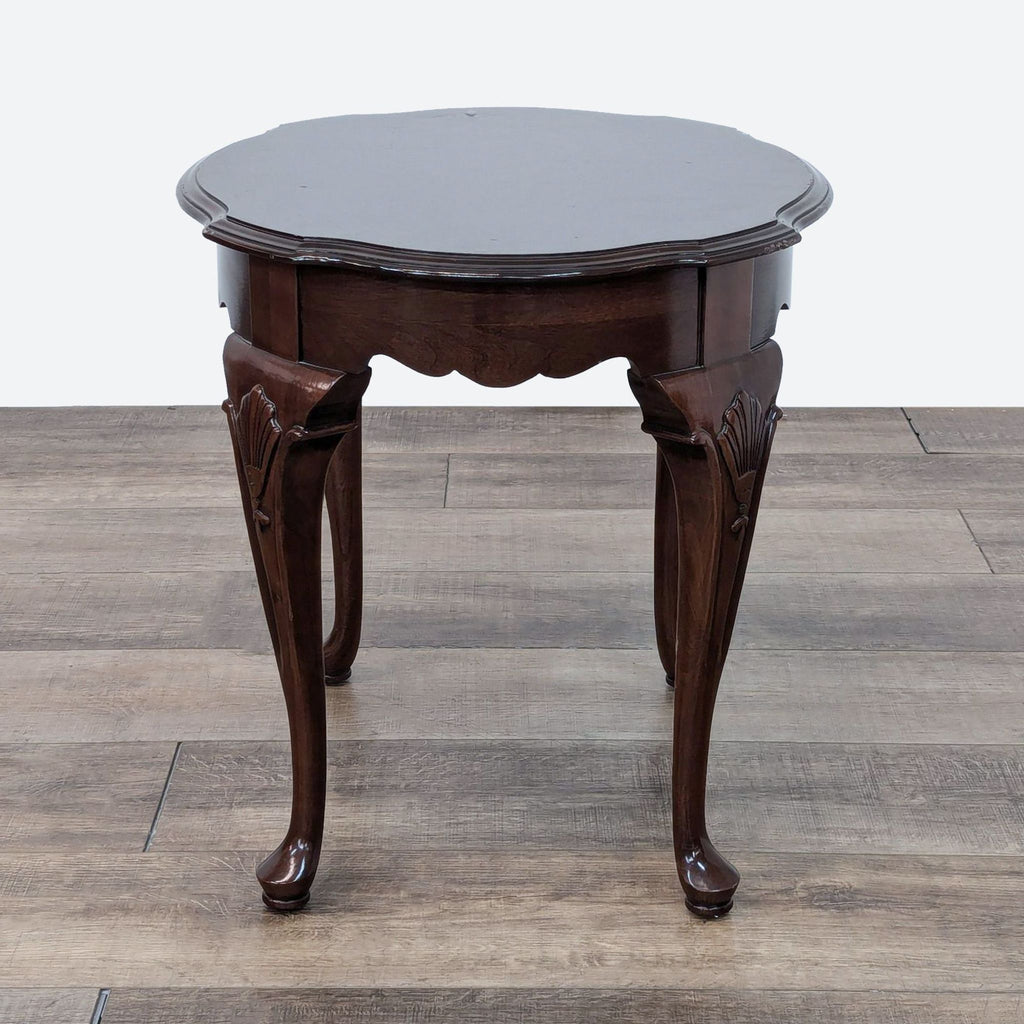 a small round table with a dark brown top and a dark brown top.