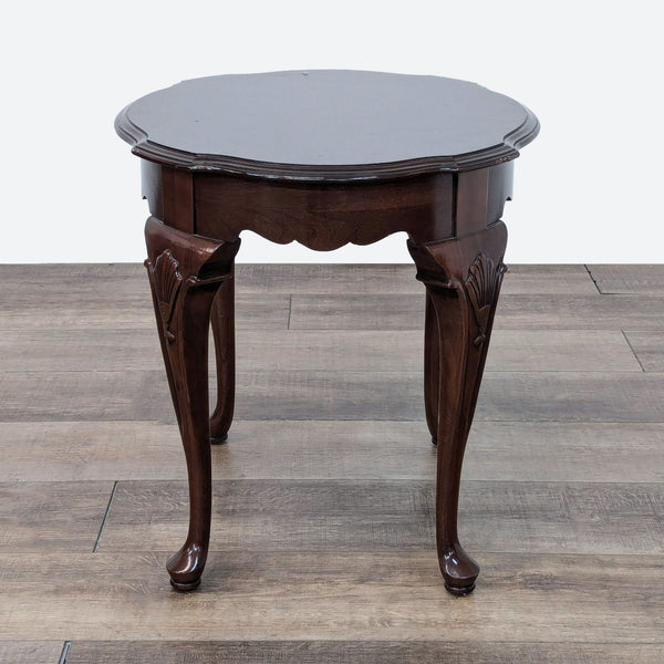 a small round table with a dark brown top and a dark brown top.